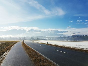 Road by landscape against sky