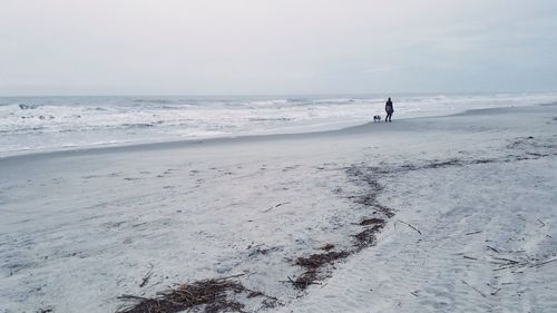 Person standing on beach against sky