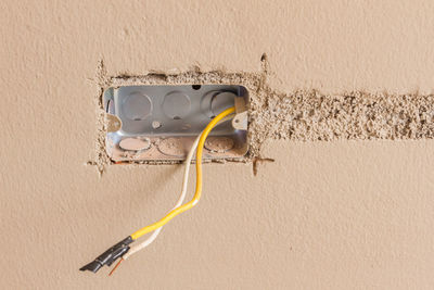 Close-up of yellow telephone on wall