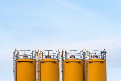 Four silos in front of blue sky