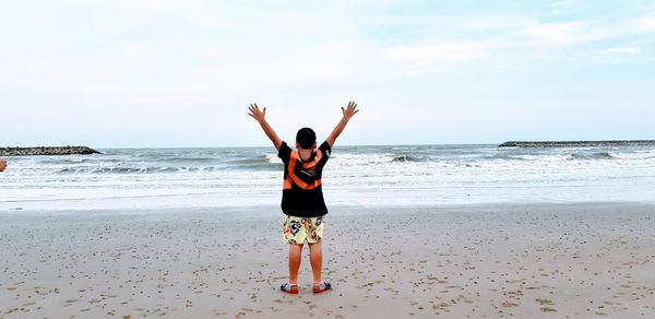 Full length of boy on beach against sky