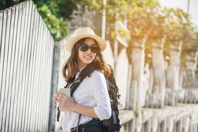 Close-up of young woman wearing sunglasses standing outdoors