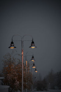 Low angle view of illuminated street light against sky