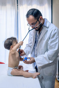 Doctor observing a one-year-old baby