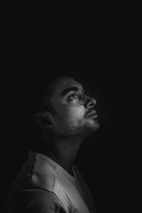 Portrait of young man against black background