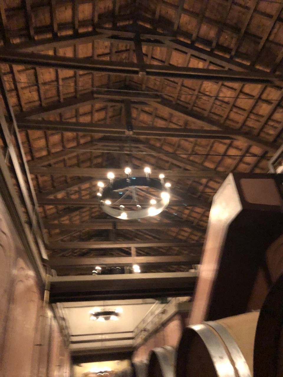 LOW ANGLE VIEW OF ILLUMINATED PENDANT LIGHTS HANGING IN CEILING