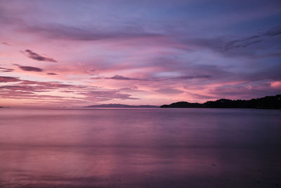 Scenic view of sea against dramatic sky during sunset