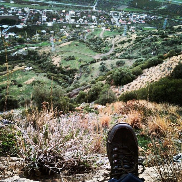 low section, shoe, person, standing, personal perspective, lifestyles, high angle view, men, leisure activity, jeans, footwear, field, casual clothing, landscape, mountain, nature, grass