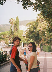 Young people standing against trees