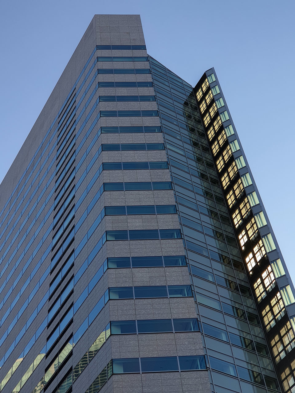 LOW ANGLE VIEW OF MODERN BUILDING AGAINST BLUE SKY