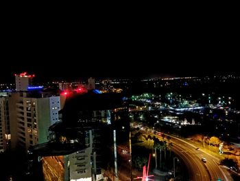 Illuminated cityscape against sky at night