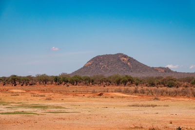 Scenic view of arid mountain landscapes against sky at tsavo west national park in kenya