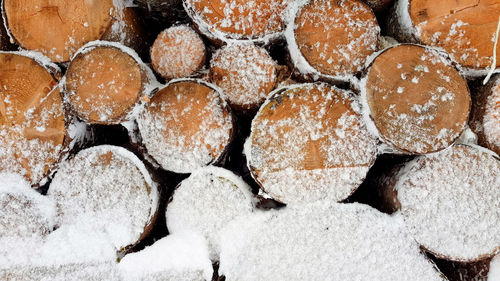 Logs, firewood, wood covered with snow.