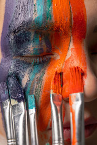 Close-up of young woman painting face