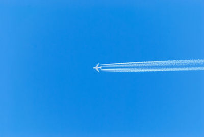 Distant view of airplane flying in clear blue sky