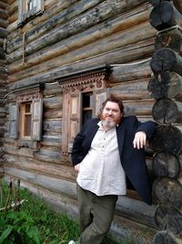 Portrait of smiling man standing against brick wall