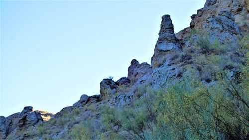 Low angle view of rock formation against clear blue sky