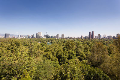 Panoramic view of trees and buildings against clear sky