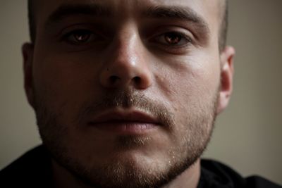 Close-up portrait of young man against wall