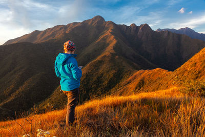 Full length of man standing on mountain against sky