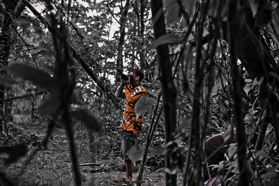 Woman standing on tree trunk