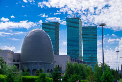 View of modern buildings against cloudy sky