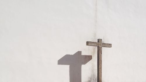 Close-up of cross sign against sky