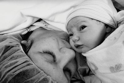 Close-up of mother kissing newborn baby girl