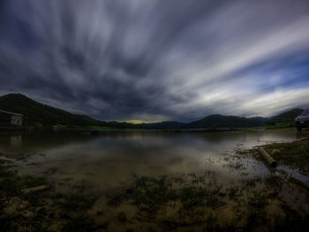 Scenic view of lake against cloudy sky