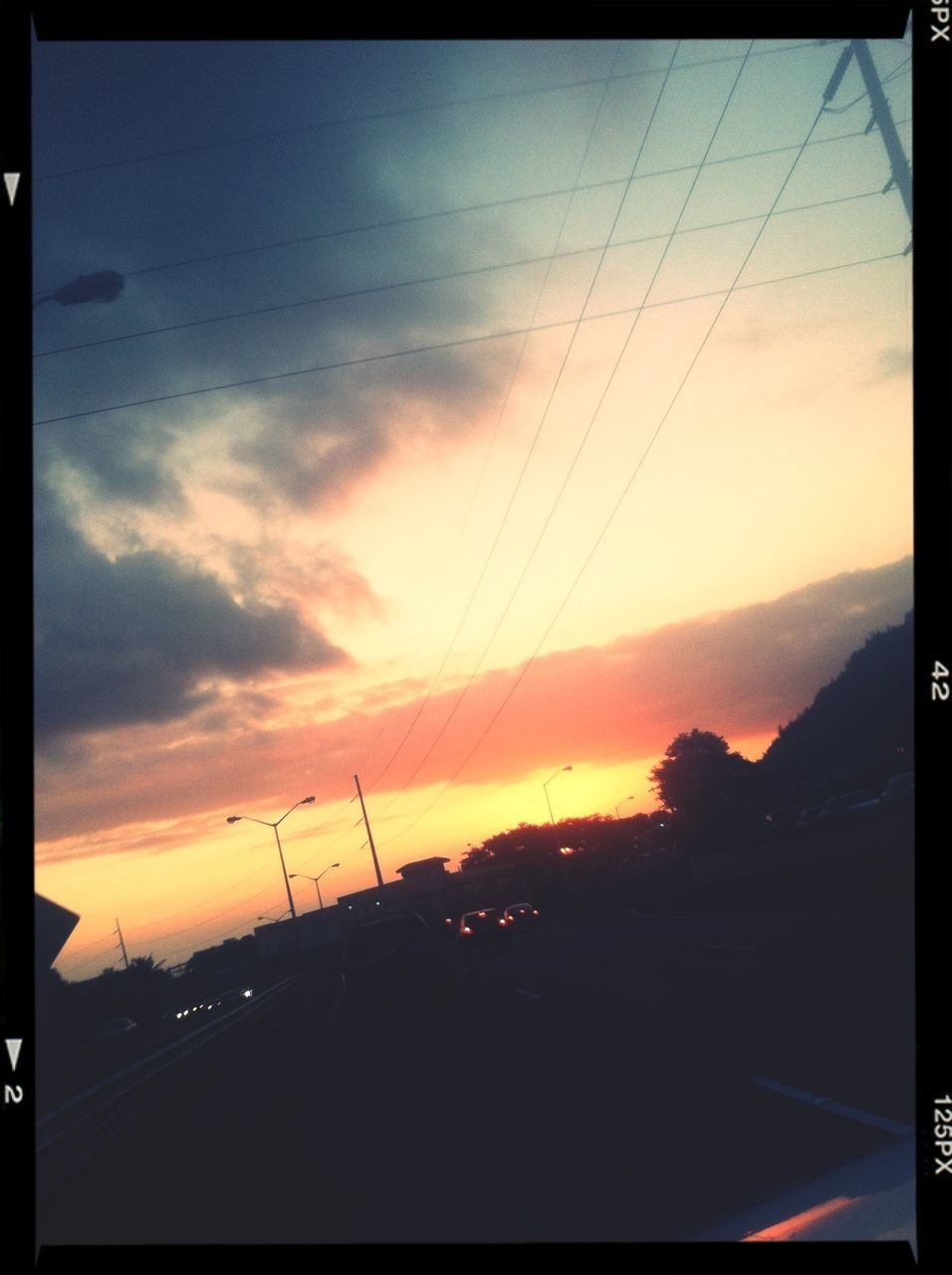 sunset, transfer print, sky, transportation, silhouette, orange color, auto post production filter, car, road, cloud - sky, scenics, power line, beauty in nature, mode of transport, nature, cloud, sun, no people, outdoors, street light