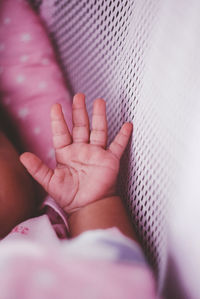 Close-up of baby hand on bed