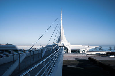 Suspension bridge over sea against clear blue sky