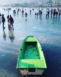 People and boat on frozen lake