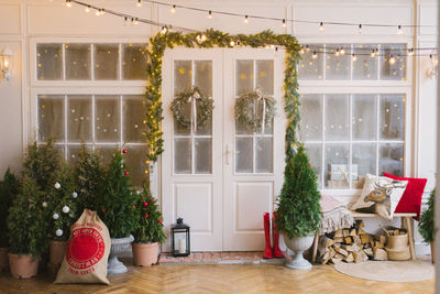 The white private house is decorated with small christmas trees and lanterns, a bag of gifts