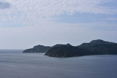 Scenic view of sea and mountains against sky