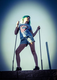 Low angle view of woman standing against sky