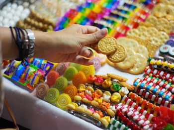 Cropped hand buying candy in store