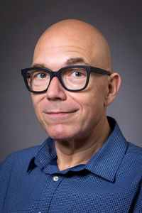 Portrait of young man wearing eyeglasses against black background