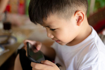 Close-up portrait of boy holding camera