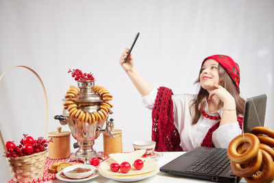 Portrait of woman holding christmas decoration on table