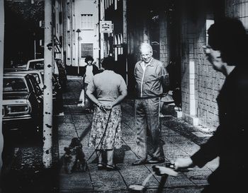 Rear view of people walking on street in city