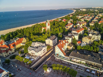 High angle view of townscape by sea against sky