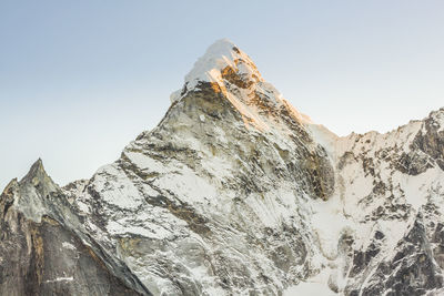 Low angle view of snowcapped mountains against clear sky