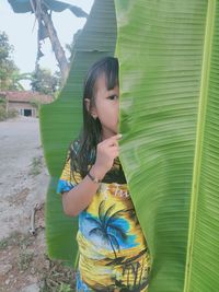 Girl looking away while standing outdoors