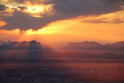 Scenic view of dramatic sky over landscape during sunset
