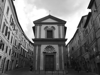 Old church amidst buildings in city against sky