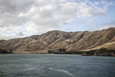 Scenic view of sea and mountains against sky