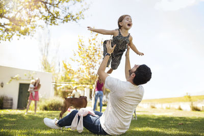 Father playing with daughter in garden