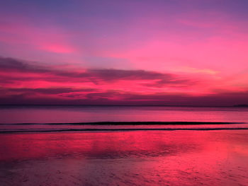 Scenic view of sea against dramatic sky during sunset