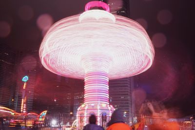 Blurred motion of illuminated ferris wheel at night